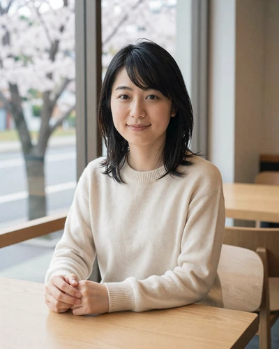 Haruka, 29, Japanese woman from Osaka in a cream sweater at a window cafe with cherry blossoms