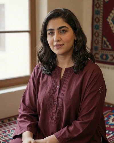 Farida, 29, verified Afghan woman from Kabul in a burgundy embroidered tunic by a window