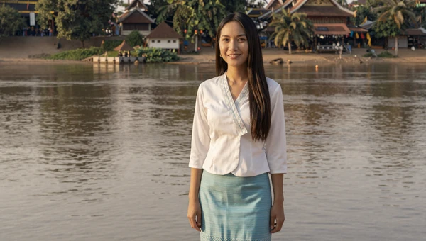 Laotian woman in a traditional sinh skirt near the Mekong River in Vientiane
