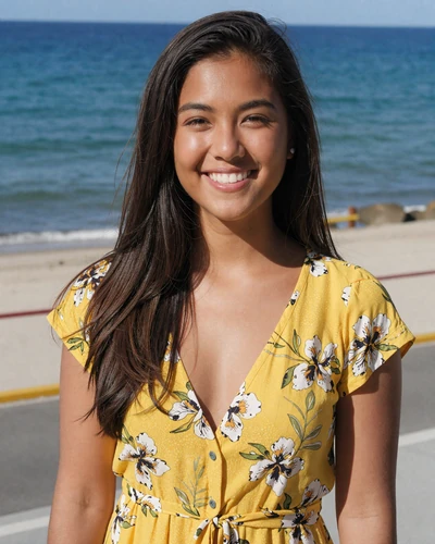Bella, 24, Filipina woman from Davao in a yellow floral top smiling at a seaside boardwalk