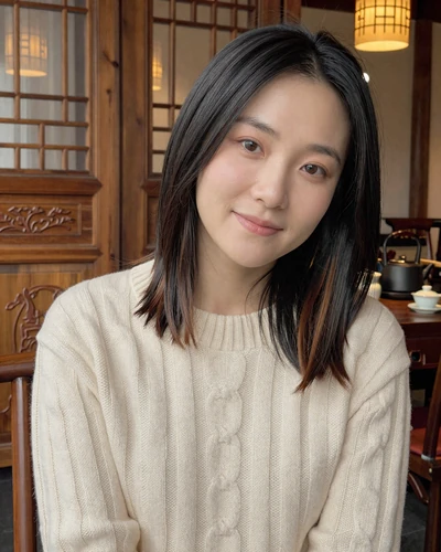 Xiao-Wen, 30, Chinese woman from Chengdu in a cozy teahouse wearing an ivory sweater