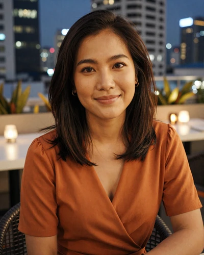 Ploy, 31, Thai woman from Bangkok at a rooftop restaurant with evening city lights behind her