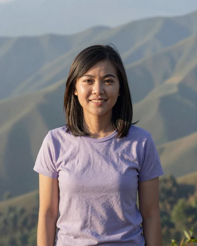 Rattana, 26, Thai woman from Chiang Rai on a mountain overlook with misty hills behind her